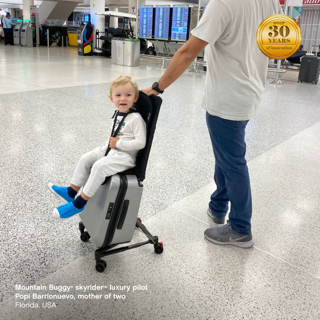 toddler at the airport riding on our skyrider™ ride on suitcase - Mountain Buggy skyrider™ luxury pilot Popi Barrionuevo, mother of two, Florida, USA