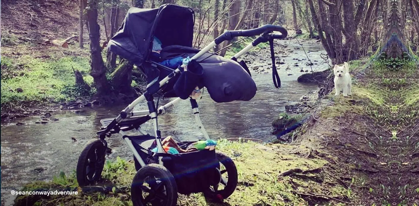 Mountain Buggy urban jungle pushchair with carrycot – parent facing position beside woodland stream